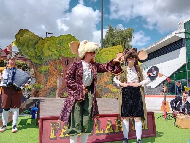 Two people dressed as animals performing on a stage