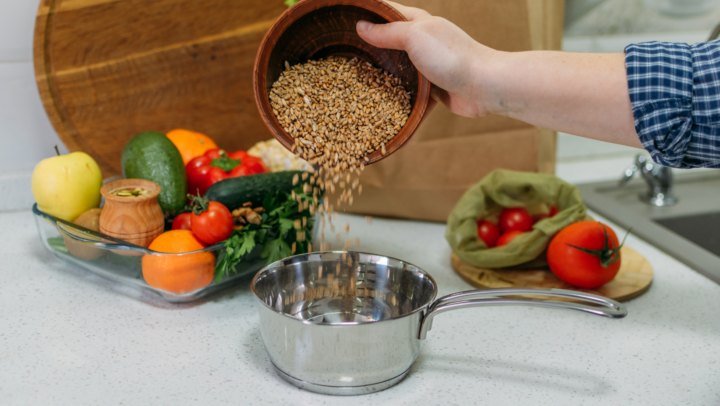 a photo showing someone preparing a meal with a variety of fresh ingredients! You’ve got grains, tomatoes, an onion, an avocado and an apple.