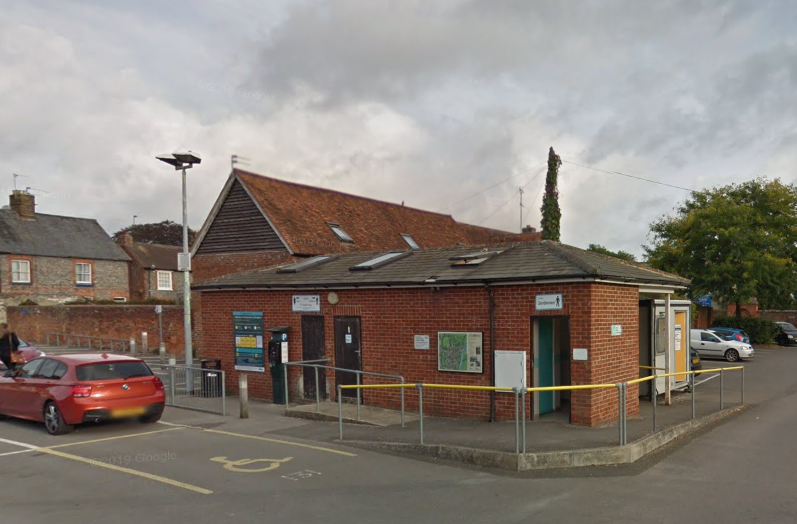 Exterior shot of old toilet block next to car park