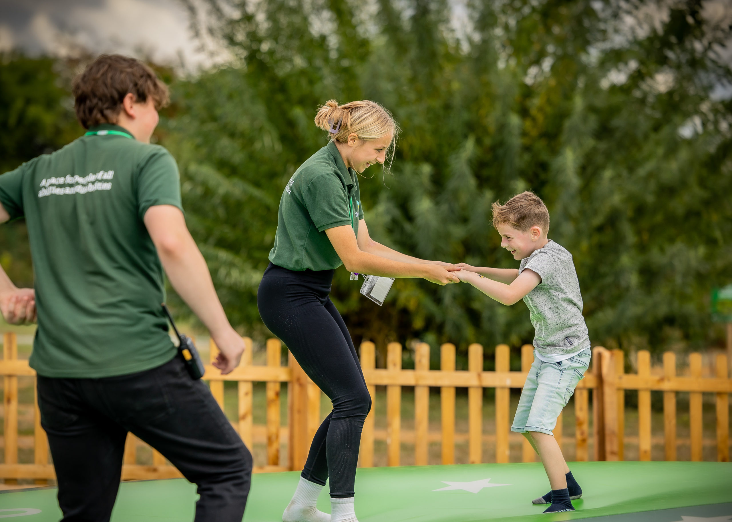 Thomely staff member holding hands while jumping with child