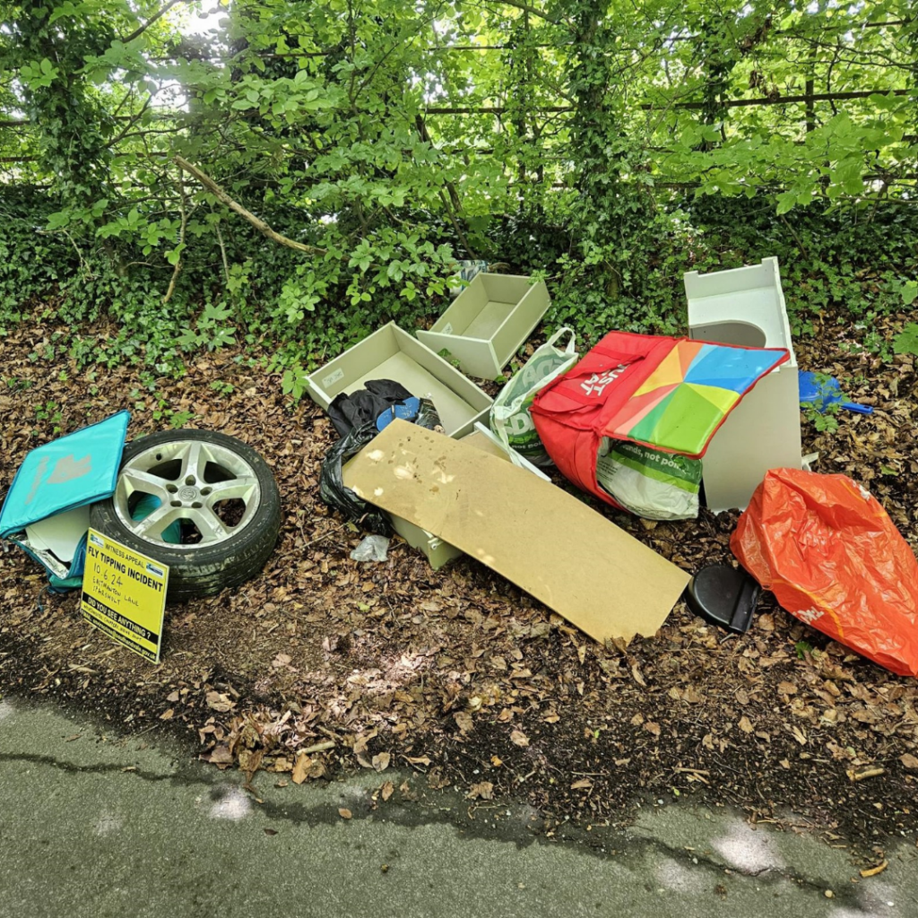 A photo of a pile of rubbish including drawers and a tyre