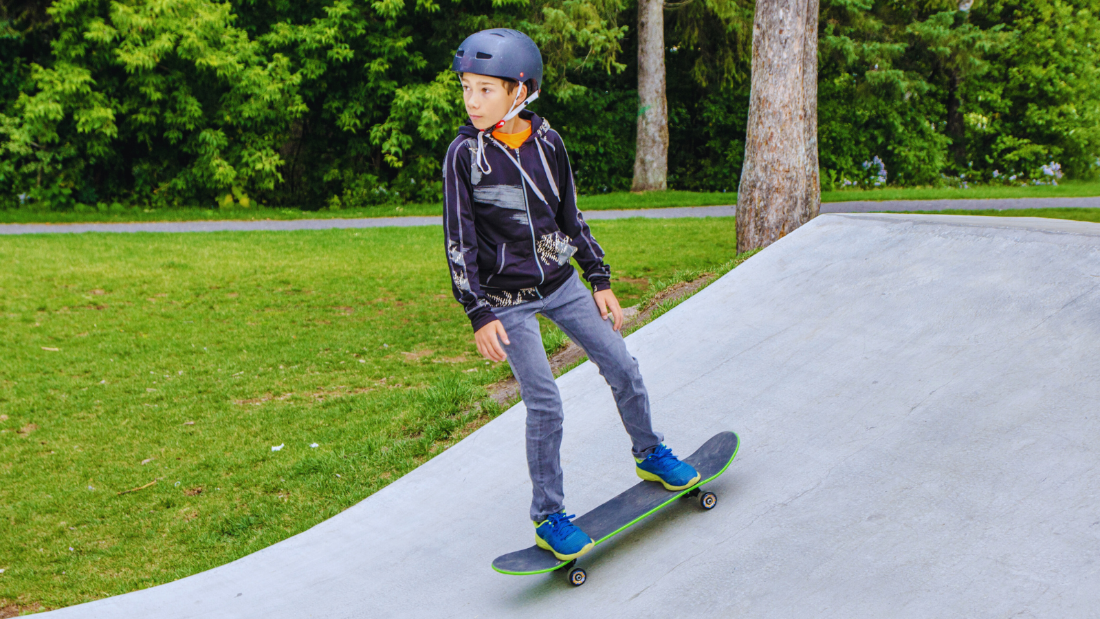 A photo of a child on a skateboard riding down a ramp